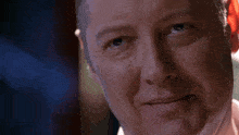 a close up of a man 's face with a slight smile