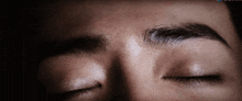 a close up of a person 's face with their eyes closed and a blue arrow pointing to the bottom right