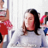 a woman is sitting at a table with a cheerleader in the background and talking to a man .