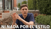 a man in a blue shirt says " ni nada por el estilo " in white letters