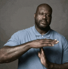 a man wearing a blue shirt is clapping his hands