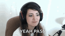 a woman wearing headphones is sitting in front of a microphone and says `` yeah pass '' .