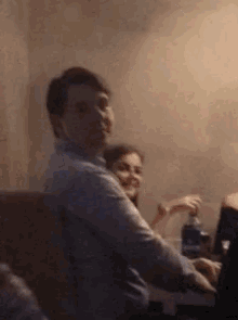 a man and a woman are sitting at a table in a room .