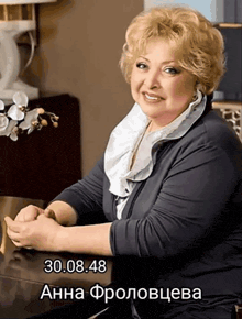 a woman is sitting at a table with the date 30.08.48