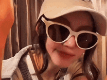 a woman wearing sunglasses and a baseball cap
