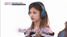 a woman wearing headphones with korean writing on the bottom right
