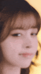 a close up of a young woman 's face with a yellow background
