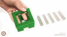 a person is playing with a green cube that says " love "