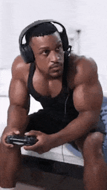 a muscular man wearing headphones is playing a video game .