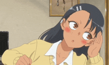 a girl in a yellow sweater has her hand to her ear