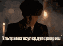 a man in a suit and hat is standing in a dark room with a foreign language written on the bottom
