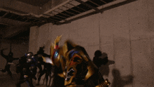 a man in a black and gold armor holds a large sword