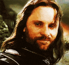 a man with long hair and a beard is smiling