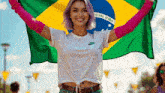 a woman is holding a brazilian flag in her hands