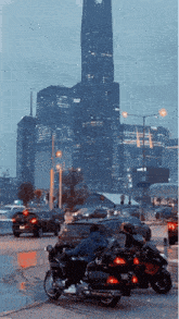 a group of motorcycles are driving down a street in front of a city skyline