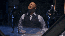 a man in a suit stands in front of a screen that says so let 's say for the moment our interest