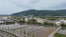 an aerial view of a city with mountains in the background and a few buildings