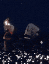 a person is standing in a field of flowers at night with a flashlight .