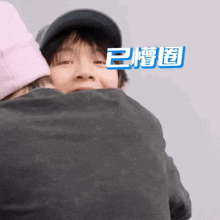 a man in a baseball cap is hugging another man in a black shirt