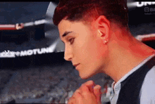 a young man with red hair is standing in front of a crowd .