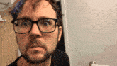 a man with glasses and a beard looks surprised