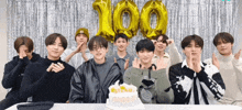 a group of young men are posing for a picture in front of balloons that read 100