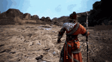 a man in a red and silver outfit is holding a spear