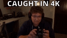 a man is taking a picture with a camera with the words caught in 4k above him