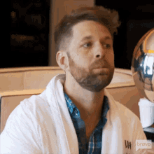 a man with a beard wearing a white robe with the word bravo on it