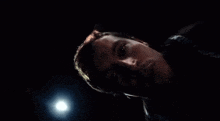 a man in a dark room with a light shining on his face