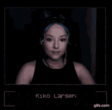 a woman with blue hair is wearing headphones and the name kiko larsen is on the screen
