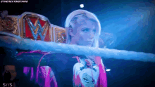 a woman in a wrestling ring with a w belt on her back