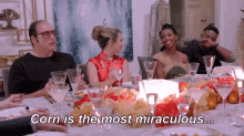 a group of people are sitting at a table with glasses of wine and food .