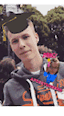 a young man wearing a graduation cap and a hoodie is holding a dog .