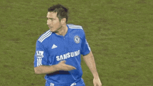 a soccer player wearing a blue samsung jersey is running on the field