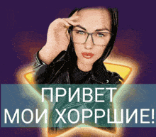 a woman wearing glasses and a black jacket stands in front of a star with the words " привет мои хорошие " written on it