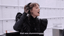 a woman in a black dress is sitting in a chair and says that was stunningggg .