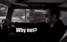 a man driving a car with the words " why not " behind him