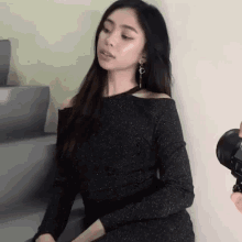 a woman in a black dress is being photographed with a camera .