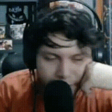 a man wearing headphones is talking into a microphone .