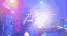 a woman is singing into a microphone on a stage with purple lights behind her