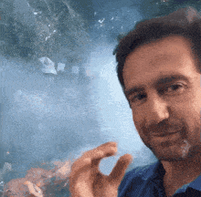 a man in a blue shirt is giving a thumbs up