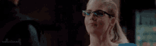 a woman wearing glasses and a ponytail is smiling at a man .