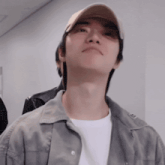 a man wearing a baseball cap and a grey jacket looks up