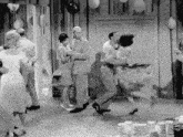 a group of people are dancing in a room with balloons
