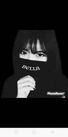 a black and white photo of a girl wearing a mask with the word bella on it .