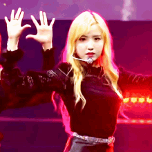 a woman with blonde hair is wearing a black top and a microphone around her neck