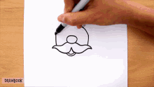 a person is drawing a mustache on a piece of paper that says drawbook on the bottom