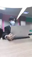a man wearing a mask is sitting in front of an hp laptop