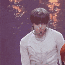 a man in a white shirt is dancing on a stage with a microphone .